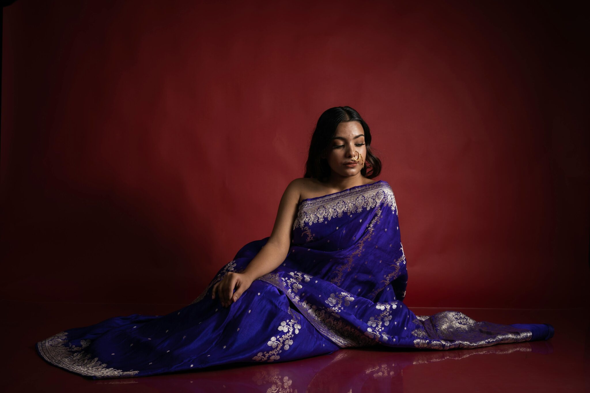 A serene portrait of a woman in a vibrant blue saree, embodying elegance and tradition.